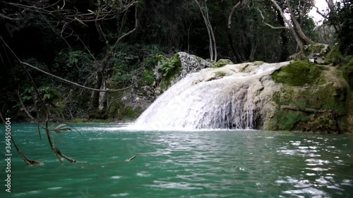 Small Waterfall Flowing by The Dense Forest In Greece In Summer.  - wide shot photo