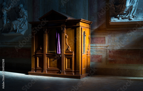 Wooden confessional in the old church in the sunlights photo