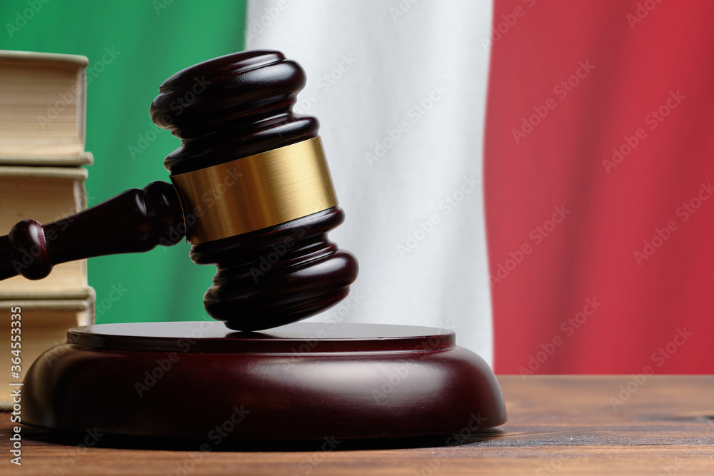 Justice and court concept in Italian Republic. Judge hammer on a Italy flag background Justice and court concept in Italian Republic. Judge hammer on a Italy flag background