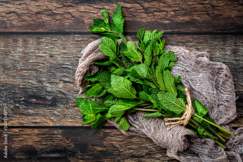 Top view of bunch of fresh green aromatic mint twigs arranged on rustic wooden table photo