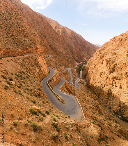 From above of majestic landscape of narrow winding roadway going between rough rocks against blue sky