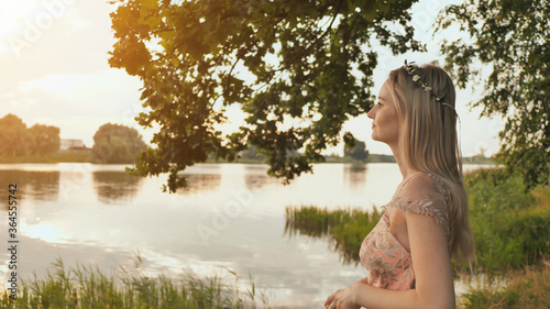 Beautiful young blond woman outdoors portrait near the lake.