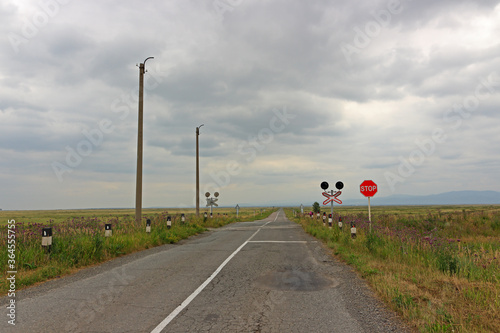 Empty road on the steppes of Khakassia. Cloudy summer day in Siberia