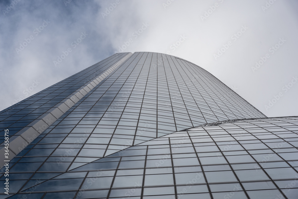 © Juan Lopez/ADDICTIVE STOCK - Low angle of contemporary high rise building facade with glass exterior under white cloudy sky in modern city district © Juan Lopez/ADDICTIVE STOCK - Low angle of contemporary high rise building facade with glass exterior under white cloudy sky in modern city district