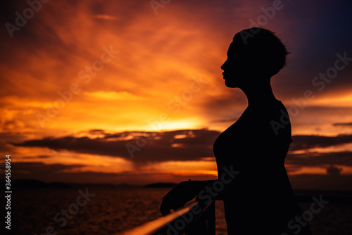 Silhouette of a girl on a sunset background.