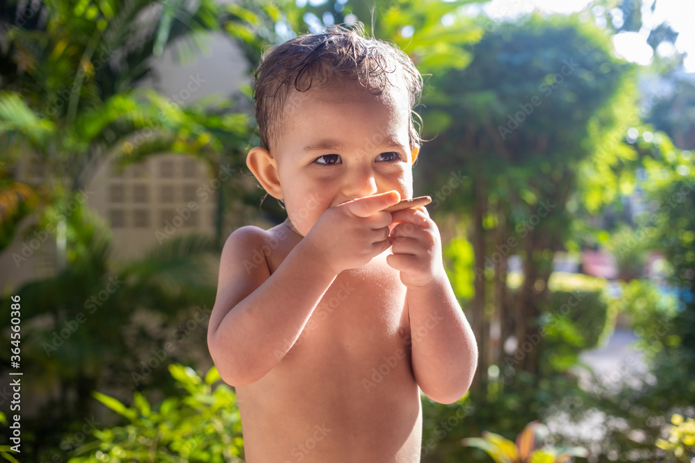 Fototapeta premium cute toddler baby with appetite eating cookies on a sunny day.