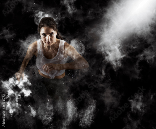 Sporty young woman running on smoke background © Andrey Burmakin