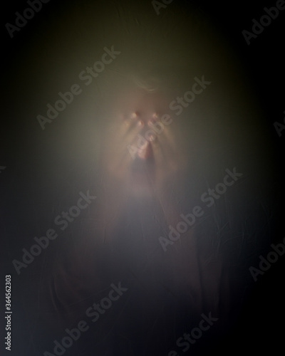 Фотография Vague defused blurry image of an unidentifiable mature male man with hands over