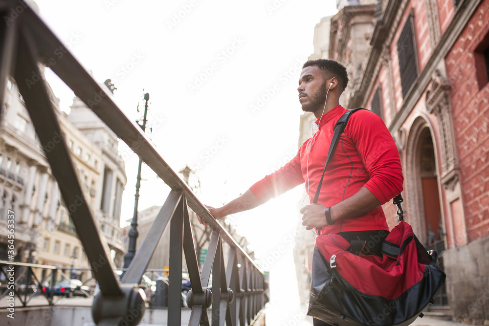 Young man walking around the city wearing sportswear Young man walking around the city wearing sportswear