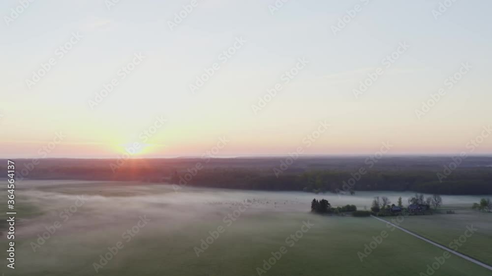 Sun rises over mist covered field and countryside Sun rises over mist covered field and countryside