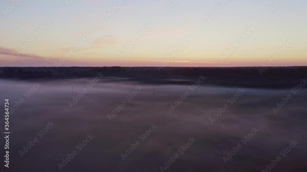 Powerlines on a field in mist before sunrise Powerlines on a field in mist before sunrise