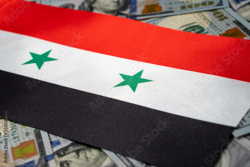 Syria flag with US dollars as background. Concept for investors, soft focus