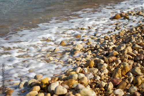 Stones being washed by an incoming tide at Ramla Bay, Gozo, Malta.