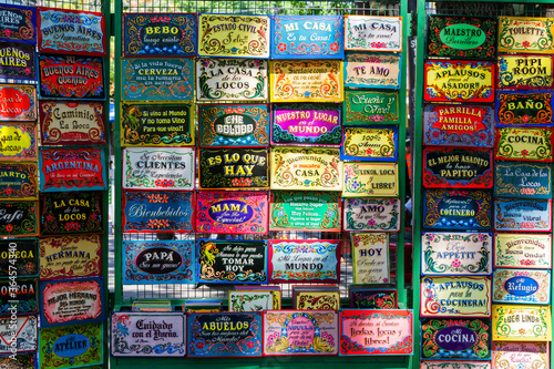 BUENOS AIRES, ARGENTINA - FEBRUARY 24, 2016: Funny spanish door welcoming boards on La Boca market in Buenos Aires district. photo