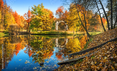 colored autumn trees in Tsaritsyno park in Moscow and a white arch on the island