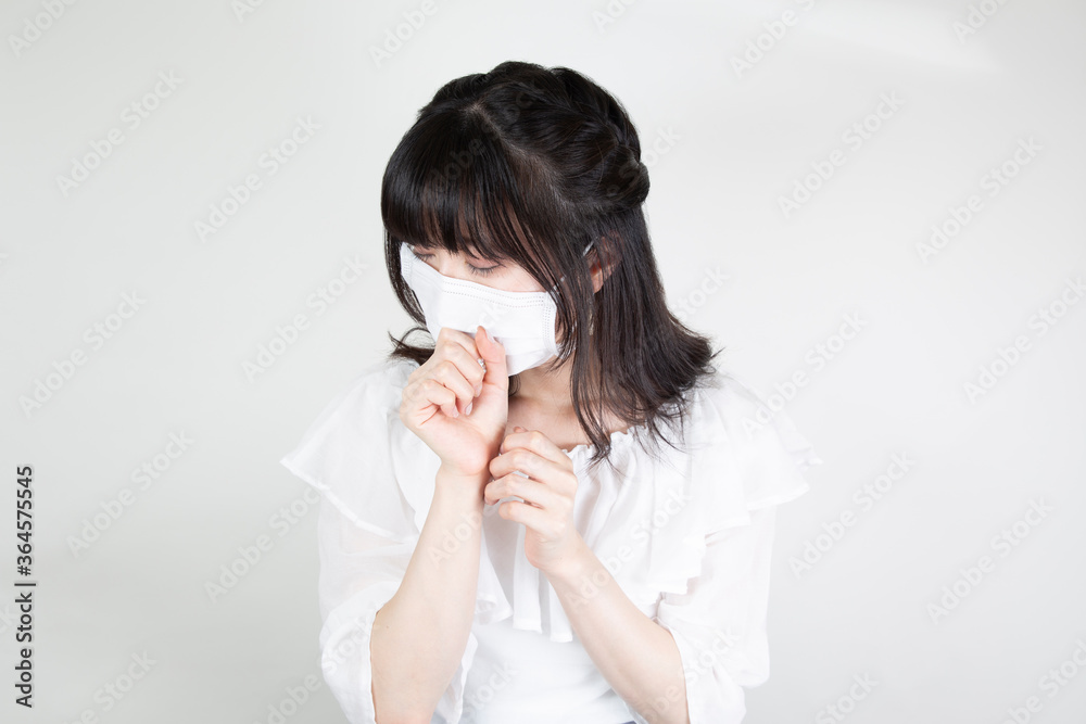 マスクをつけて咳き込む女性
