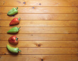 green and red sweet peppers on wooden background flat lay