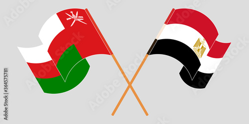 Crossed and waving flags of Egypt and Oman