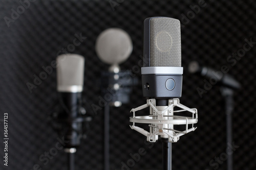 Recording studio equipment. Microphones on stands in music recording studio on black dark background.