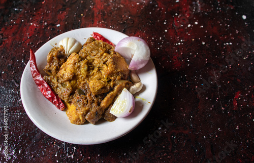 Closeup of Mangsho Kosha or Bengali Style Chicken Curry Isolated on Reddish Background with Copy Space photo