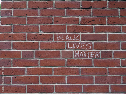 Black Lives Matter slogan scrawled in chalk on a brick wall, right justified horizontal