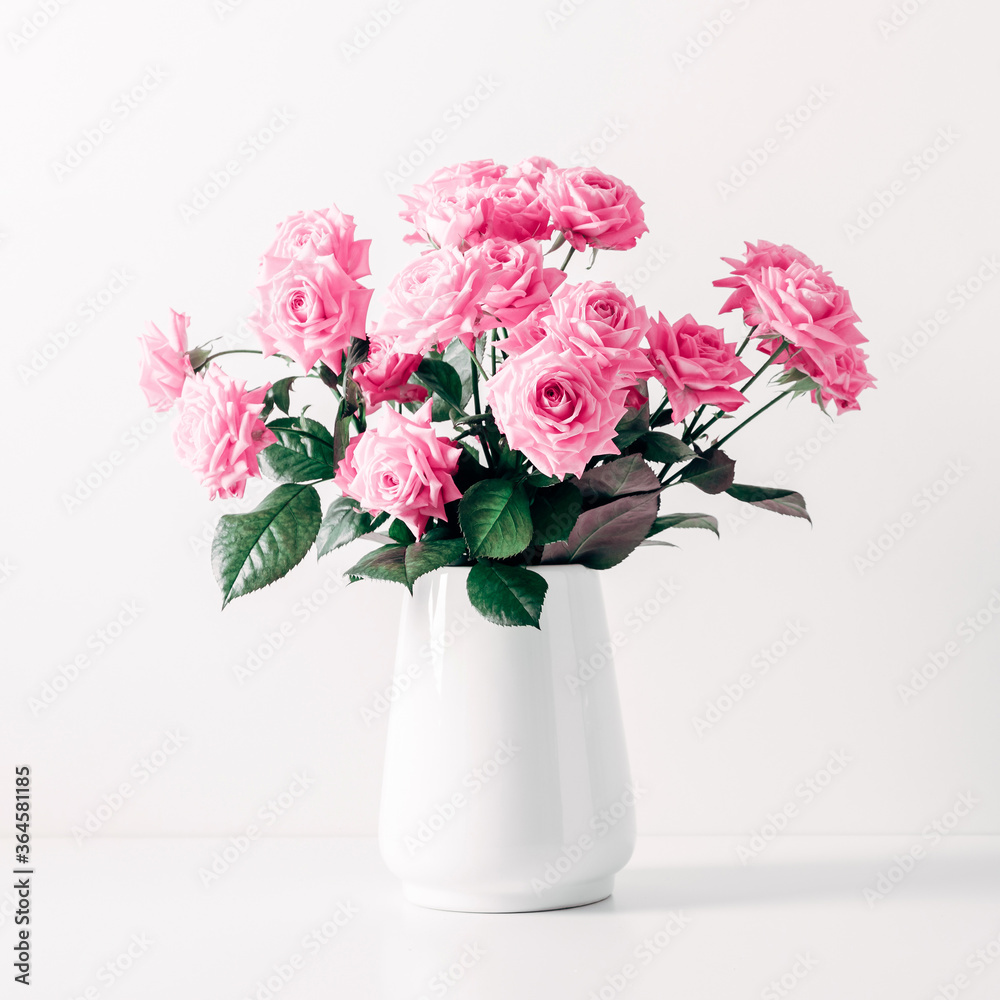 Beautiful flowers composition in interior. Pink rose flowers in vase on white background. Valentine's Day, Happy Women's Day, 8 March.