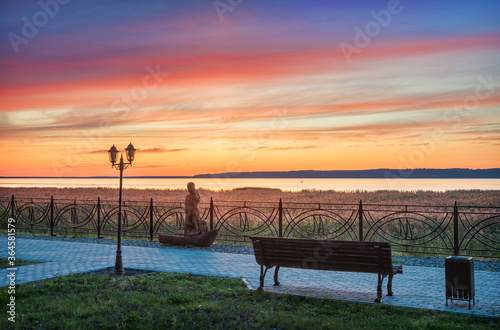 pink sunset over Lake Galich in the Kostroma region and a wooden sculpture photo