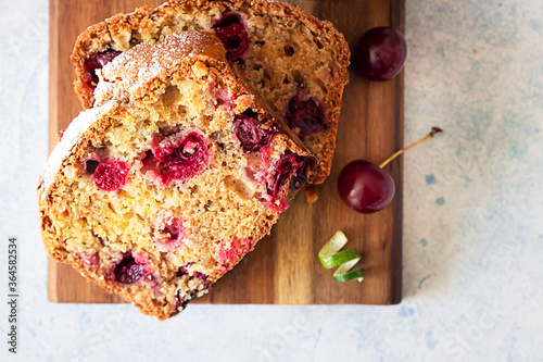Quadro su tela Slices of homemade pound cake with cherries and nuts on wooden cutting board