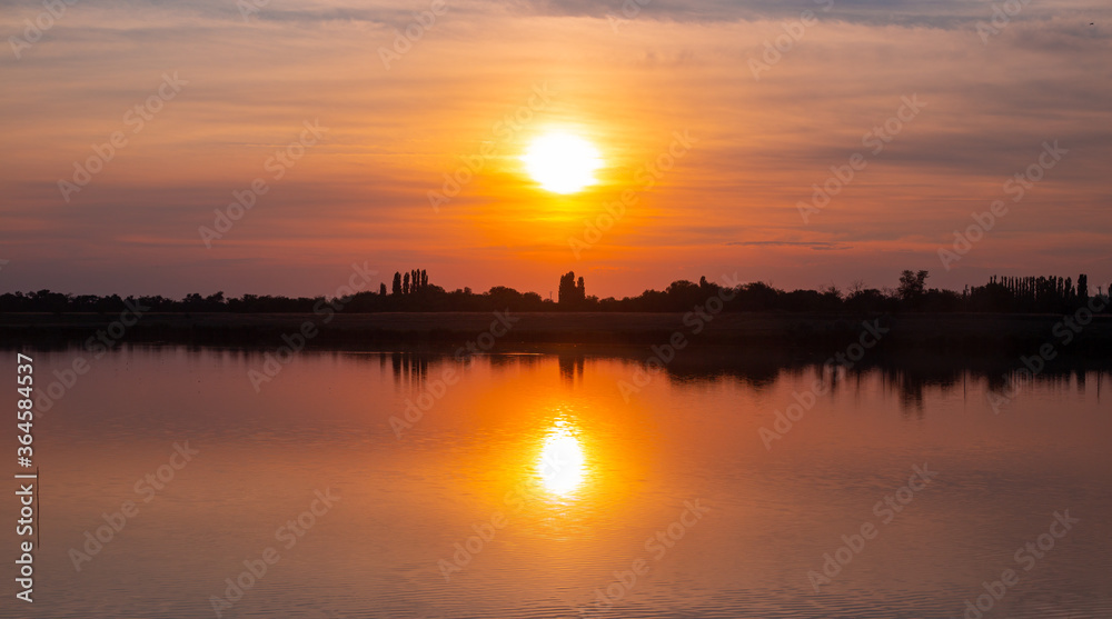beautiful orange sunset on the lake on a summer day, panoramic shot