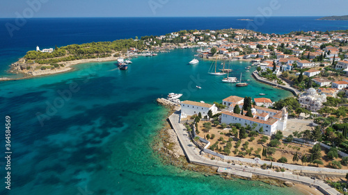 Aerial drone bird's eye view photo of picturesque neoclassic houses in historic and traditional island of Spetses with emerald clear waters, Saronic Gulf, Greece