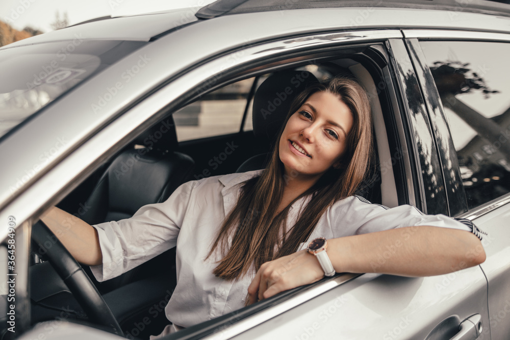 Beautiful young happy smiling woman driving her car.