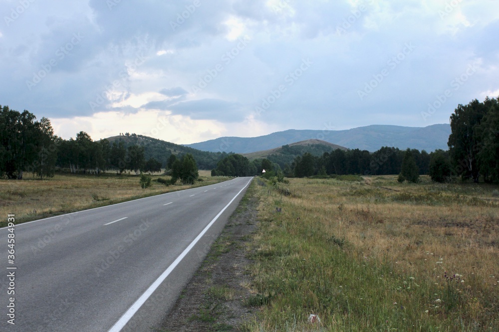 A road in the mountains going far beyond the horizon at sunset A road in the mountains going far beyond the horizon at sunset