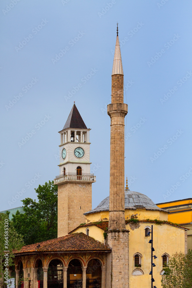 Clock tower and the minaret of Ethem Bey Mosque in Skanderbeg Square, Tirana, Albania