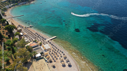 Aerial drone photo of organised with sun beds emerald beach of Kaikia in Ligoneri area near old town of Spetses island  Saronic gulf  Greece