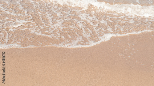 Transparent sea waves on the warm sandy seashore. Sea vacation and travel.