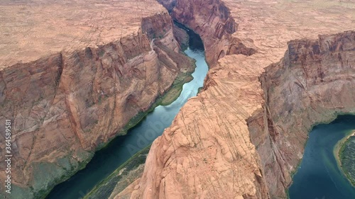 USA travel and road trip to wilderness. Drone flying along scenic Horseshoe Bend park in Arizona. 4K aerial video of beautiful nature landscape with red canyon and blue Colorado river in deep canyon