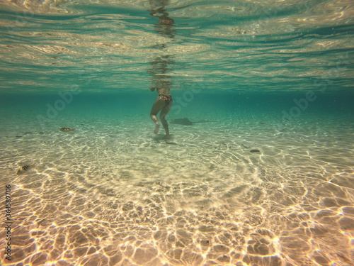 Jeune femme nageant avec une raie, lagon de Taha'a, Polynésie française © Atlantis