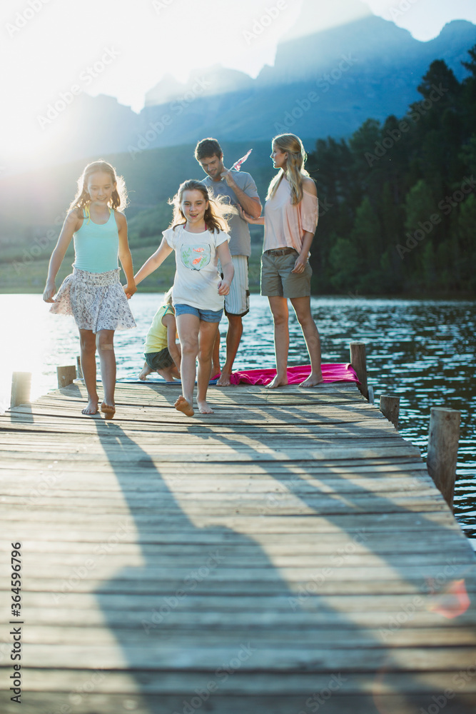 Family walking on dock over lake