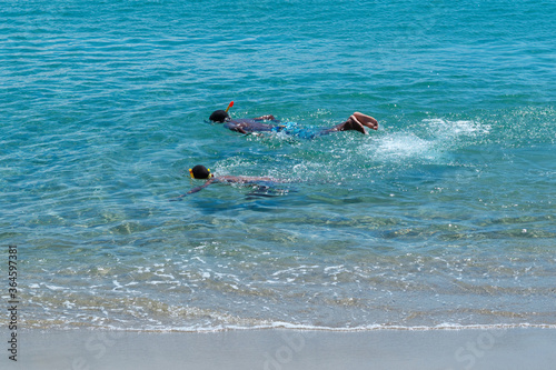 Two Black kid snorkeling in clear ocean water in Dominican Republic.