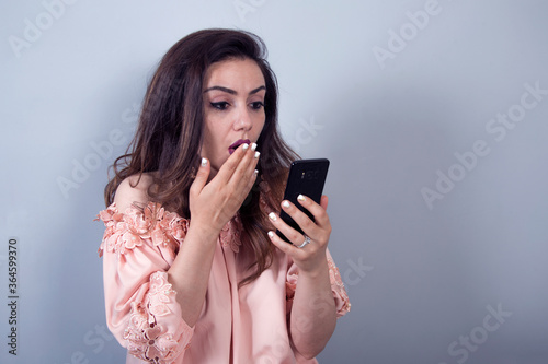 Excited young woman amazed by unbelievable shopping mobile app sale message looking at smartphone,