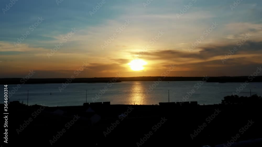 Stunning aerial drone dolly in shot flying over a historic fort with a beautiful orange golden sunset over a giant amazonian river in Joao Pessoa, Brazil. Stunning aerial drone dolly in shot flying over a historic fort with a beautiful orange golden sunset over a giant amazonian river in Joao Pessoa, Brazil.