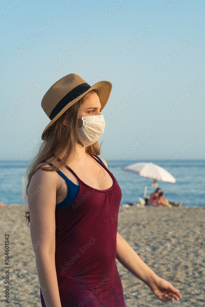 Tourist blonde girl wearing mask at the beach during summer holidays Tourist blonde girl wearing mask at the beach during summer holidays