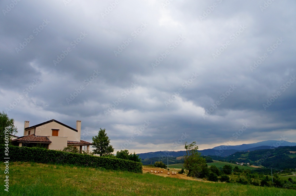 rural landscape with a house and clouds