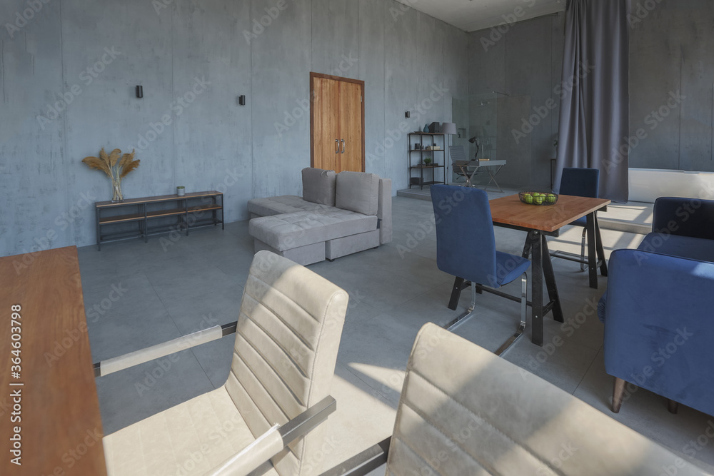Fototapeta premium Modern minimalistic dark gray loft style studio apartment interior design. kitchen, sitting area, workplace, shower and bath. bright sun rays inside.