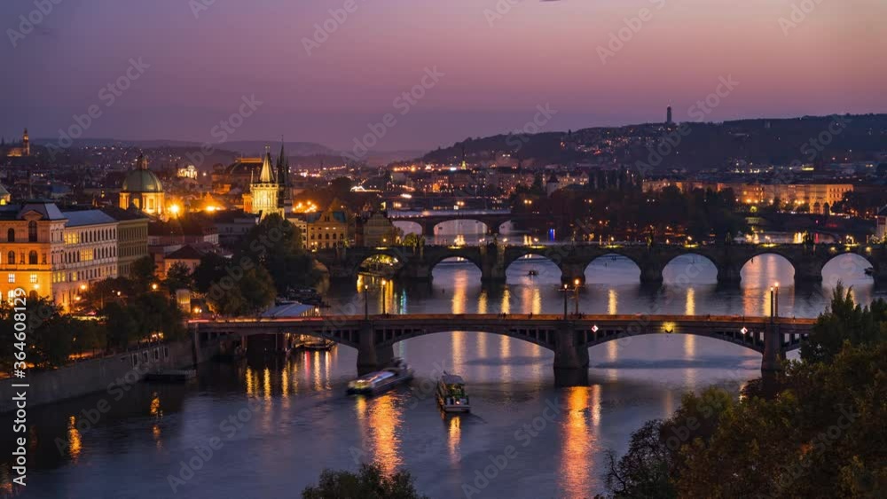 Prague, Czech Republic, timelapse view of Prague cityscape showing medieval bridges and boats on the Vltava river at dusk. 