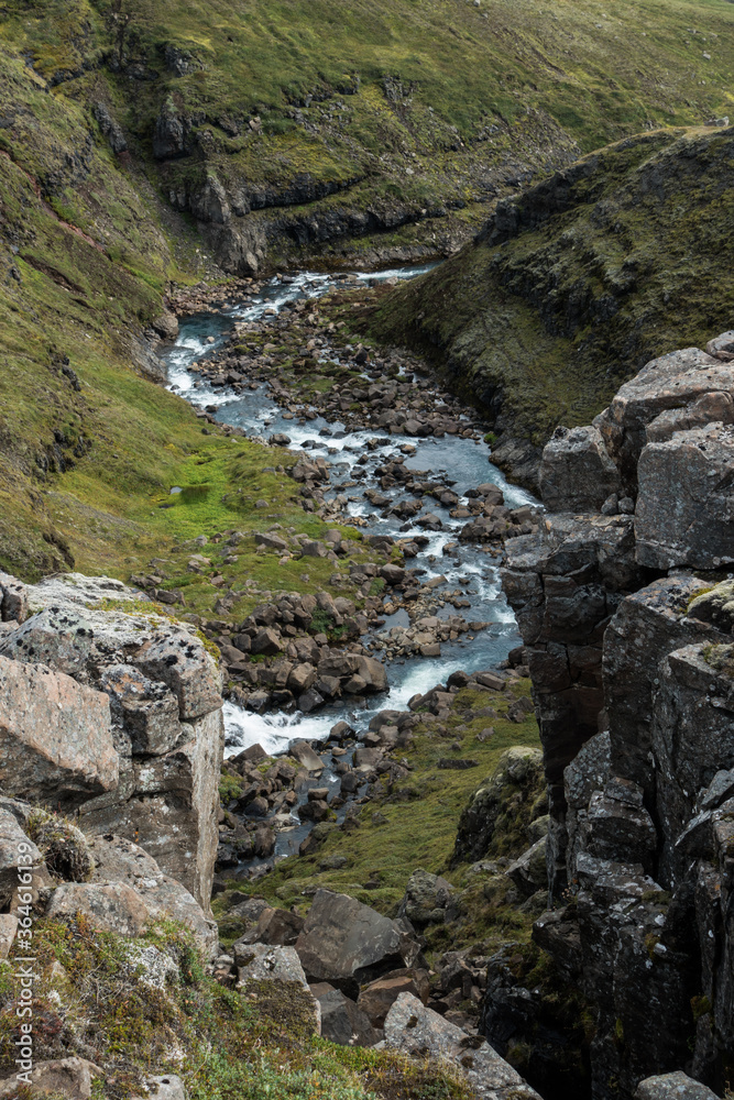 Stream of water between hills and rocks