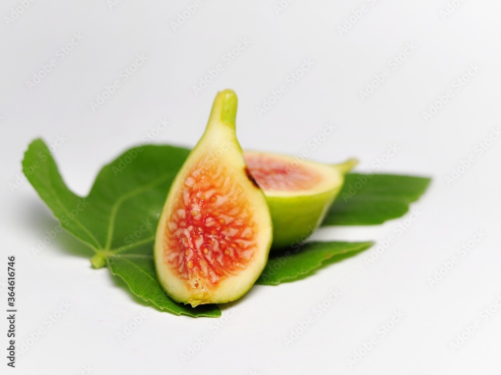 Figs fruit or ficus carica with green leaf isolated on white background Figs fruit or ficus carica with green leaf isolated on white background