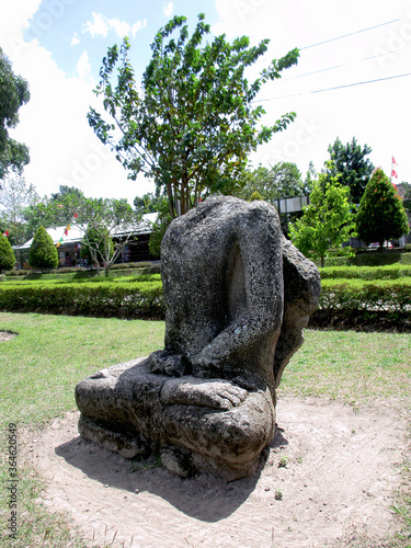 Klaten, Indonesia - August 03 2018: Side view of a headless man stone statue with meditating ascetic sitting position (bertapa/bersemedi) at Sojiwan Temple (Taman Wisata Candi Sajiwan) area. photo