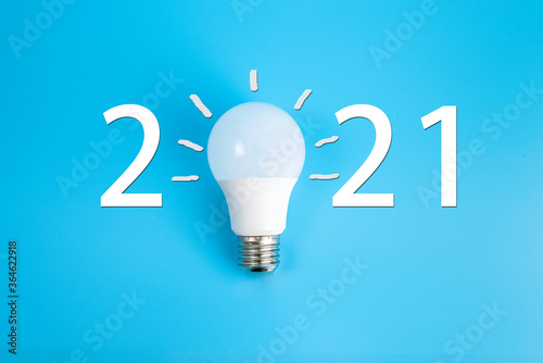 2021 created by light bulb on blue background.New Year Concept.