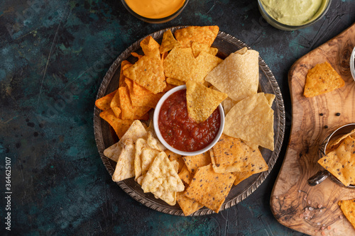Party snacks, various types of chips with dip and salsa, top view